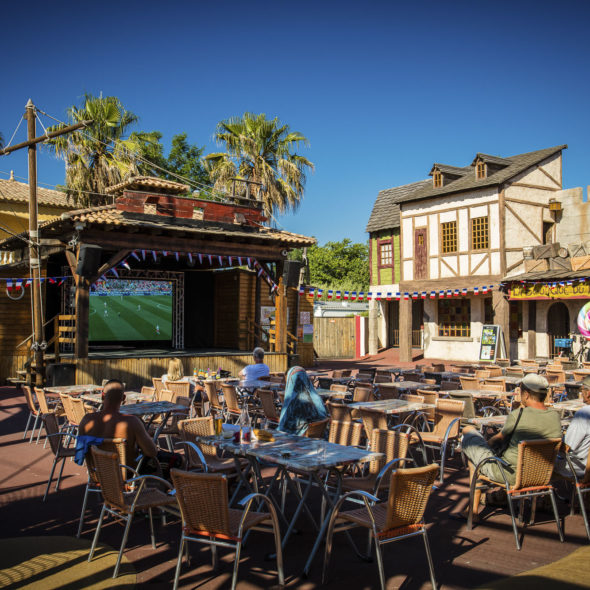Camping Californie Plage - Le cœur de village - Vue de la place des pirates avec scène de spectacle