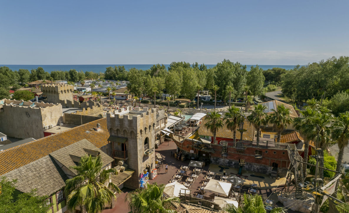 Camping Californie Plage - Le domaine - Vue aérienne de la place principale du camping avec commerces et restaurant