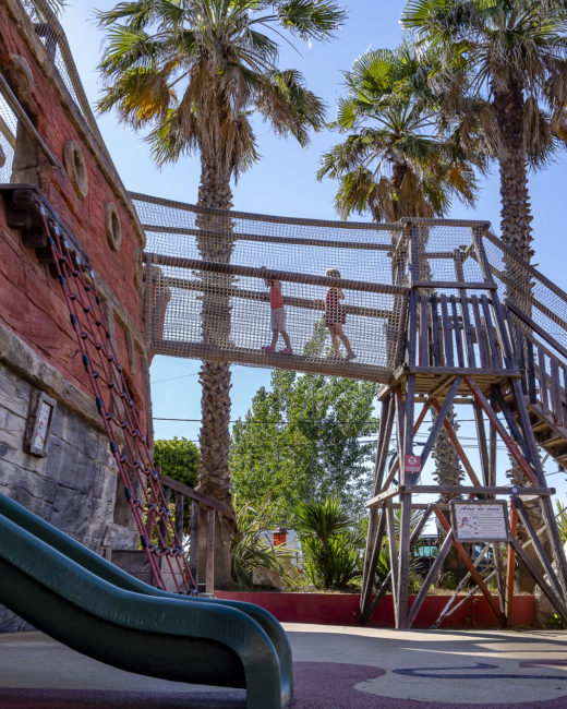 Camping Californie Plage - Galerie photo - Aire de jeux avec toboggans et pont suspendu dans l\'aire de jeux 